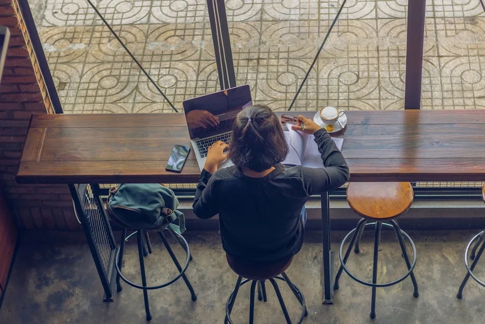 Quang/Adobe Stock High angle view of a person working remotely on a laptop.
