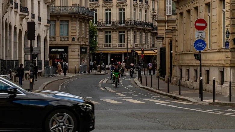 Busy Parisian street with street signs for bikes
