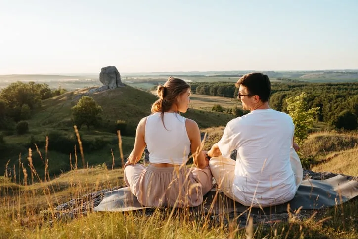 Couple sitting and overlooking a mountain.