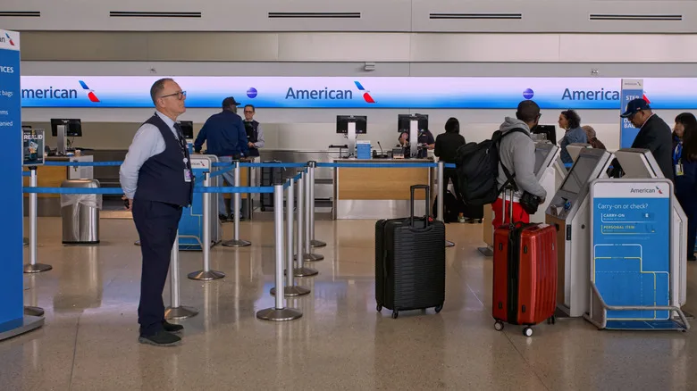 An American Airlines counter at an airport with a bag sizer pictured