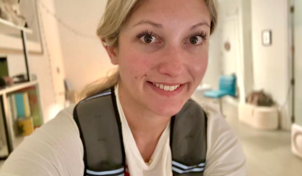 Musto rides her Peloton bike in her New York City apartment wearing a weighted vest (Julia Musto/The Independent)