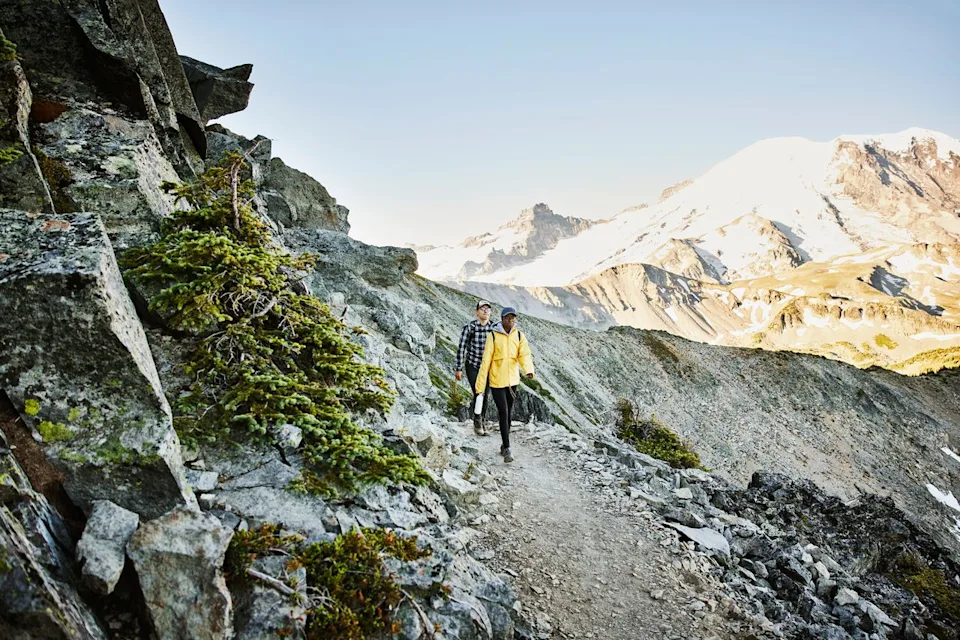 Thomas Barwick/Getty Images People hiking an alpine trail in Mount Rainier National Park.