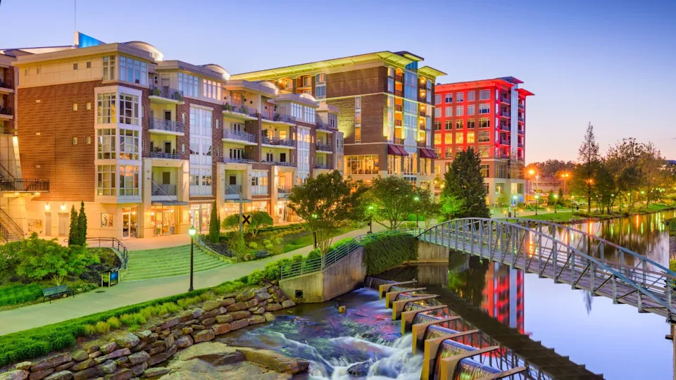 Downtown cityscape of of Greenville, South Carolina, USA on the Reedy River at dusk.