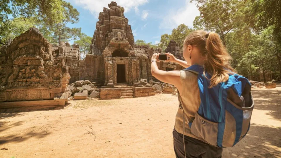 Tourist woman photographing entrance to the temple in Angkor, Cambodia