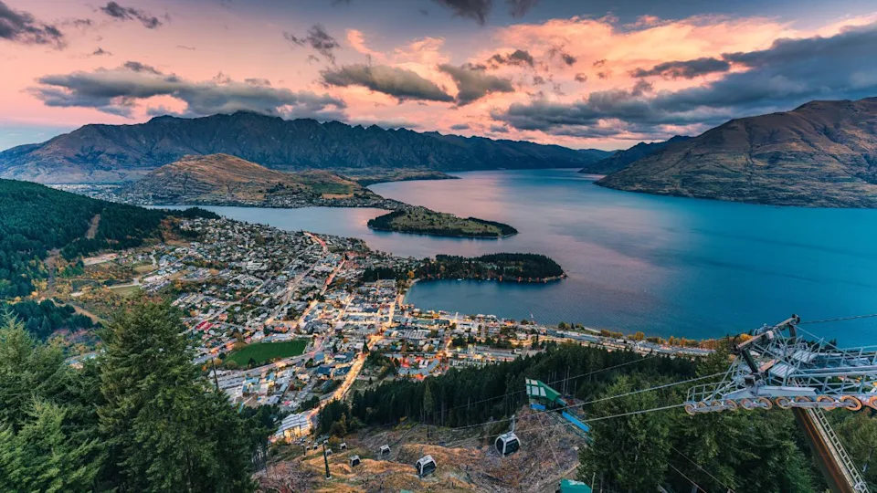 Aerial view of Beautiful sunset sky over illuminated Queenstown with Lake Wakatipu and Skyline Gondola at New Zealand