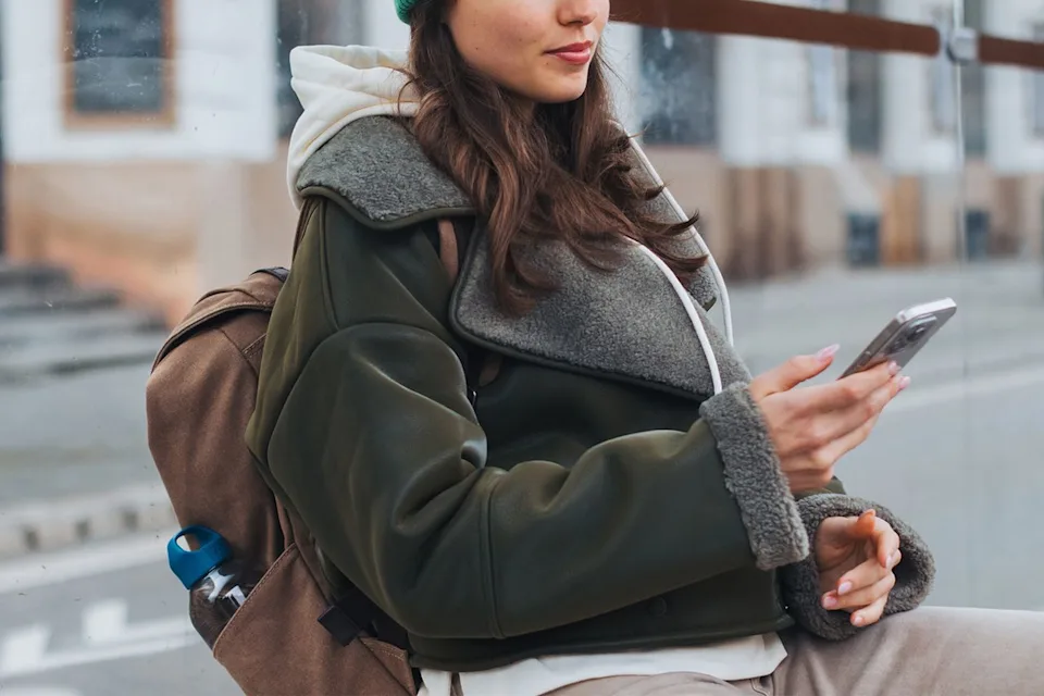 Getty Woman waiting at a bus stop