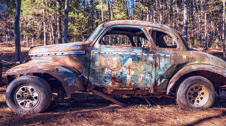 The rusted shell of a stock car rests in the nettles of the former Occoneechee Speedway