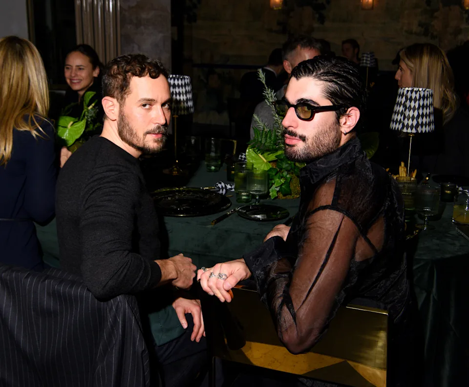 Dinner setting with two people engaged in conversation.