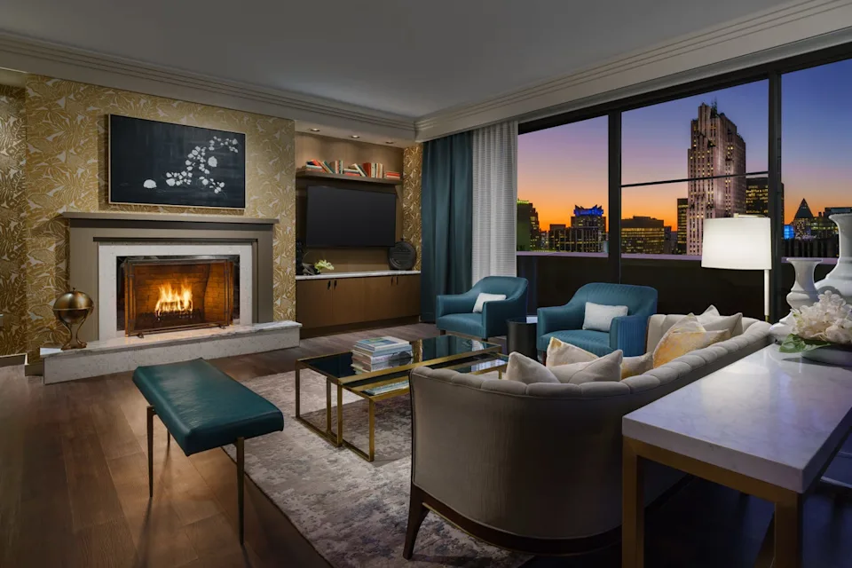 the penthouse solarium at lotte new york palace hotel, with city views and a living room with a fire place