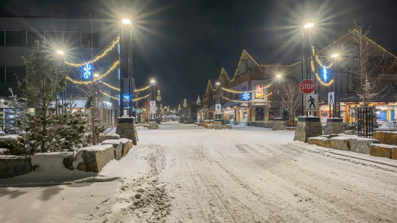 A snowy night in Banff, Canada, with festive blue and gold lights