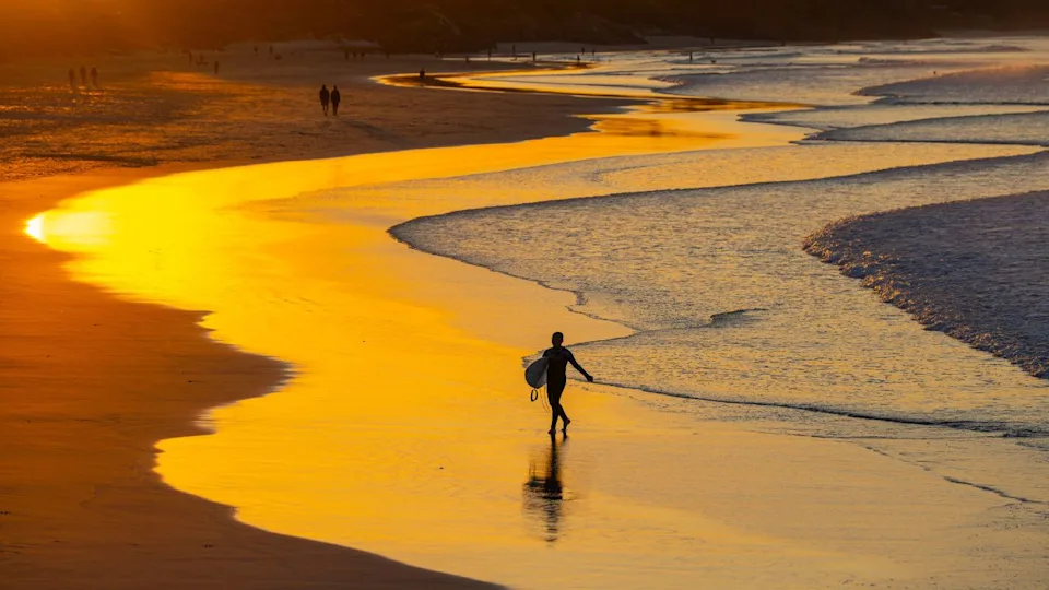 Byron Bay, July 22, 2023. Sunset view of surfers in silhouette along the Belongil Beach area in Byron Bay, New South Wales, Australia