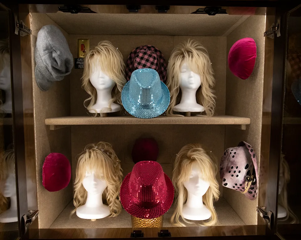 A cabinet full of wigs and hats 