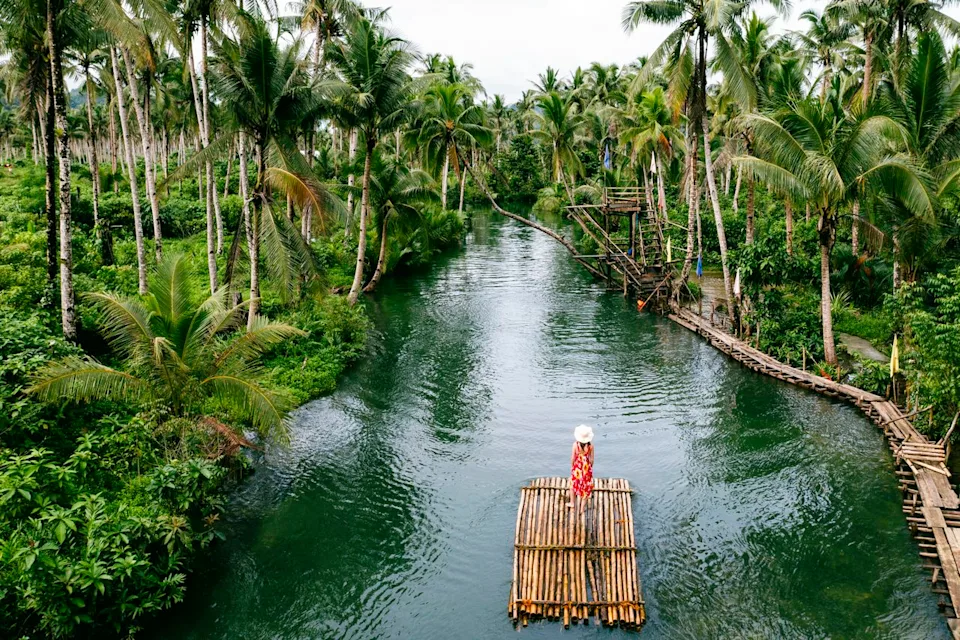 Marco Bottigelli / Getty Images A woman bamboo rafting through Bohol's Loboc River showcases the Philippines' 7,600 islands, where English proficiency and Spanish colonial heritage create cultural familiarity for Western expatriates.