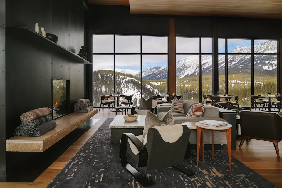 One&Only Moonlight Basin_The Landing Restaurant & Bar with hardwood floors, chic deoor, and mountain views through floor to ceiling windows