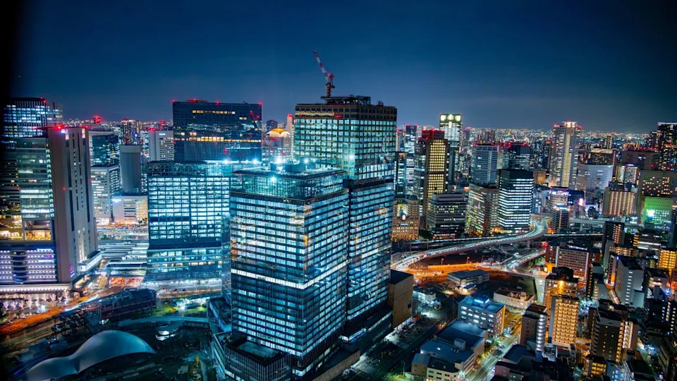 Osaka, Japan - January 10 2024: Panorama of the large skyscrapers of Osaka at night illuminated by the many lights seen from the Umeda viewpoint