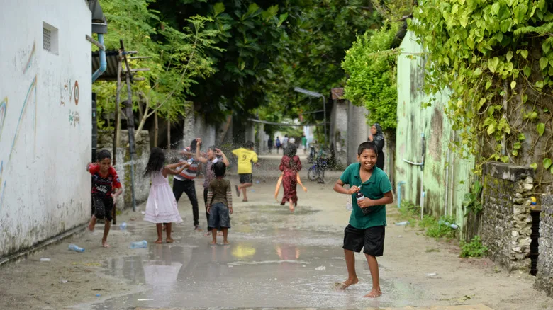 Local children play happily in the street on a Maldives island