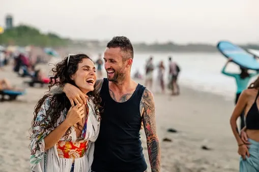 A couple walking on Kuta beach in Bali, Indonesia.