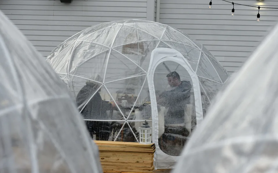 Lynn Hartness, left, and Robert O'Connor enjoy breakfast in one of the "igloos" set up for outdoor dining at Liz's Cafe on Bradford Street in Provincetown.