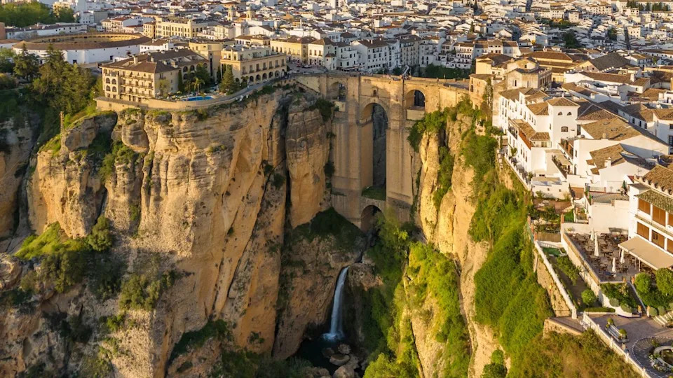 Ronda, Spain. Aerial view of the New Bridge over Guadalevin River in Ronda medieval town at sunrise, Andalusia, Spain. Famous UNESCO heritage city and Puente Nuevo bridge at sunset