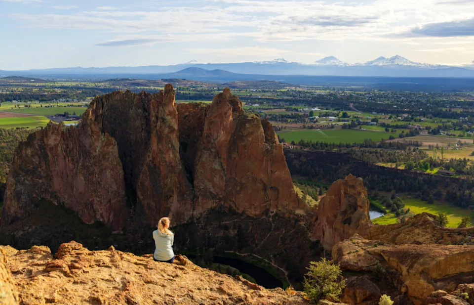 a woman sits near the top of smith rock in Bend Oregon