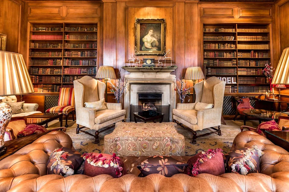 Lucknam Park, Emblems Collection A cozy fireplace warms the library.