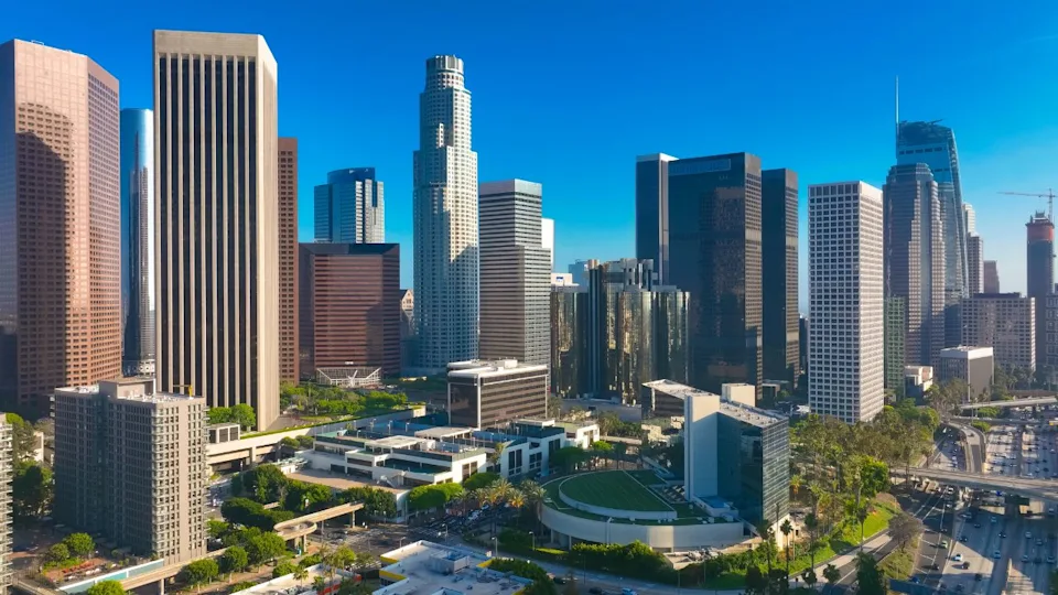 Los Angeles city. LA downtown aerial view. Los Angeles skyline. LA streets. Los Angeles from a top view. Downtown towers of Los Angeles. Panoramic scene of LA skyline. Blue sky frames the city below.
