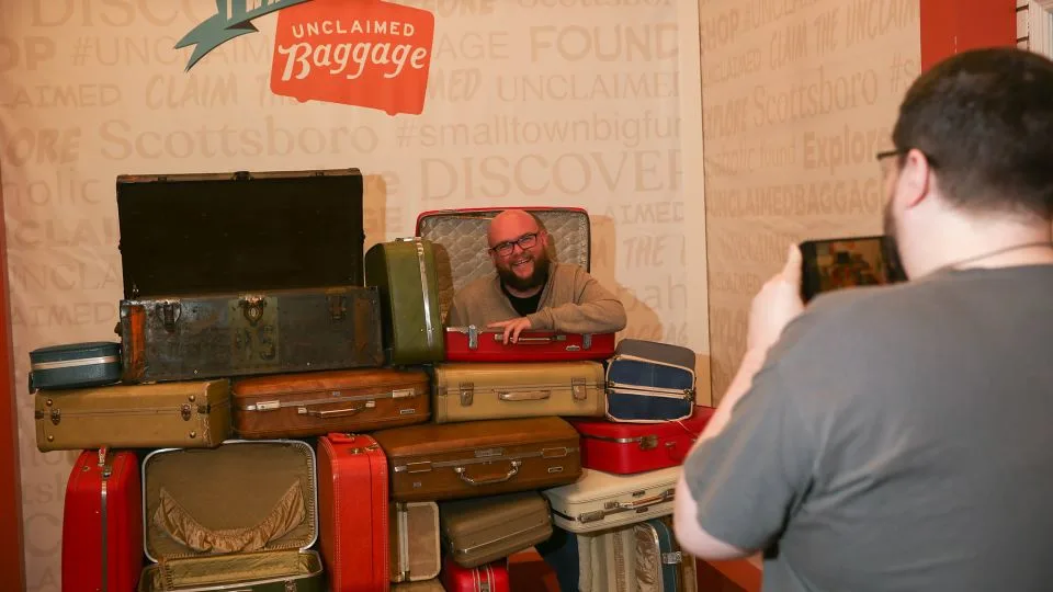 A man poses for a photo at Unclaimed Baggage in Scottsboro, Alabama. The store draws hundreds of thousands of visitors annually. - Austin Steele/CNN
