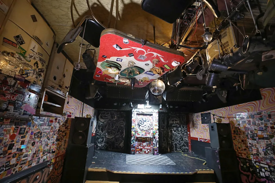 A complete set of kitchen furniture hangs overhead on the ceiling, over the dance floor, at the Bug Jar in Rochester.