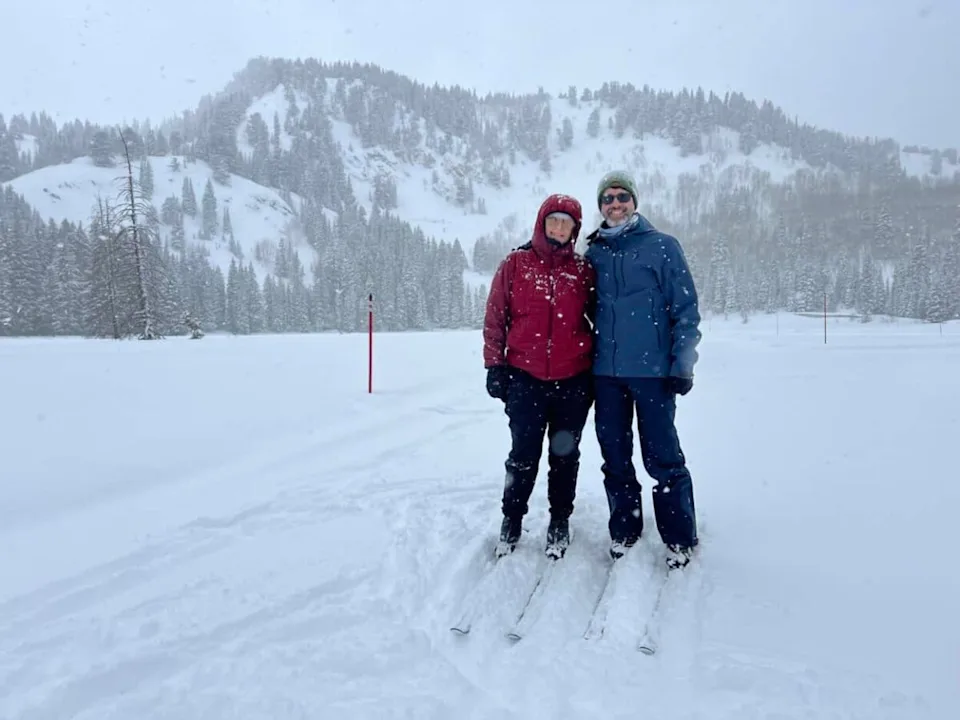 Julie and I pause for a photo during our cross‑country ski lesson in Salt Lake City as snow falls around us.