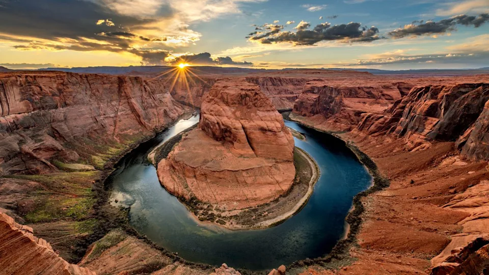 Super panorama of Horseshoe Bend in Page Arizona at sunset, showing a dramatic sky and the horseshoe shape from which the Colorado River flows.