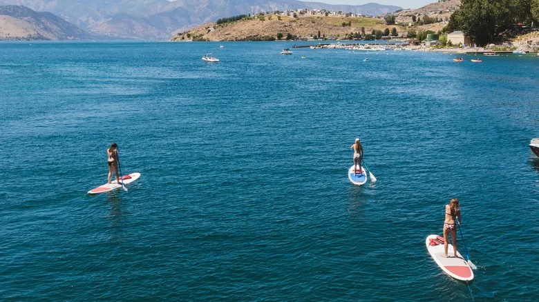 People paddle-boarding on water at Lake Chelan, Washington