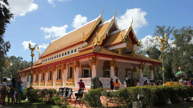 Thai temple with ornate golden details and people standing outside, near Hyde Park, Tampa