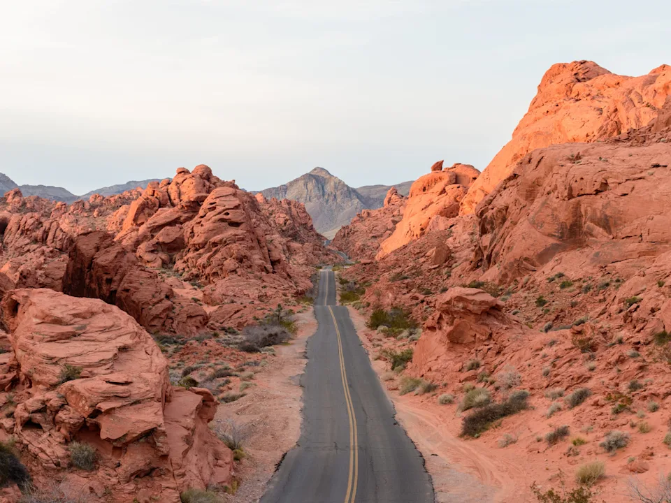 A road surrounded by large red-rock formations.