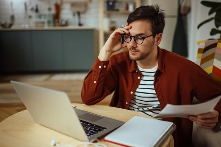 Stressed man looking at computer.