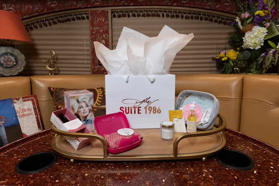 The table of the tour bus is topped with a pink purse and cosmetics