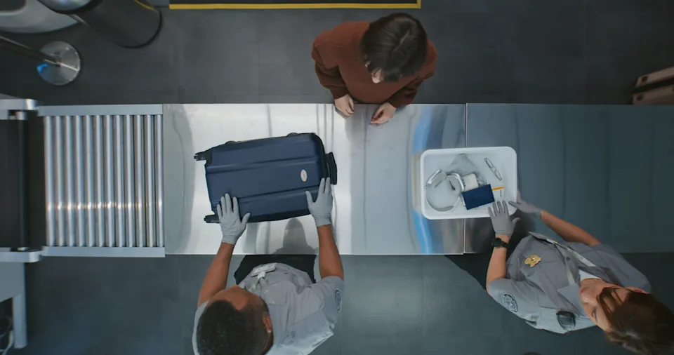 Queue of Diverse People, Passengers Putting Personal Items in Plastic Trays for X-ray Scanning. TSA Workers Controlling Screening Procedure. Airport Security Checkpoint for Boarding Flight. Top View.