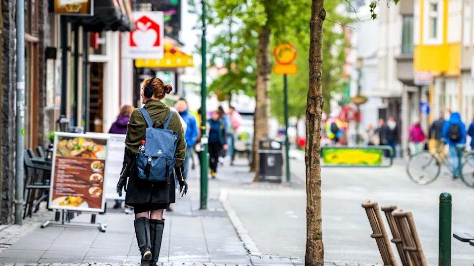 Reykjavik, Iceland - June 19, 2018: Laugavegur shopping street road and tourists on sidewalk in downtown center and signs for stores shops in summer