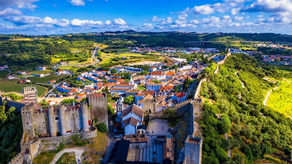 Aerial view of the historic walled town of Obidos at sunset, near Lisbon, Portugal. Aerial shot of Obidos Medieval Town, Portugal. Aerial view of medieval fortress in Obidos. Portugal.
