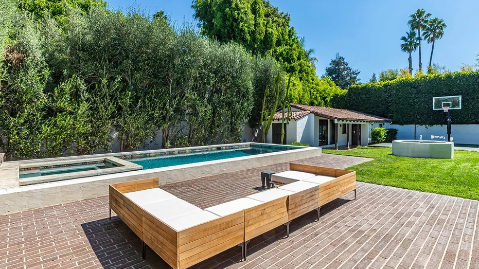 The backyard features a swimming pool and fountain, with a guest house and basketball court in the back.