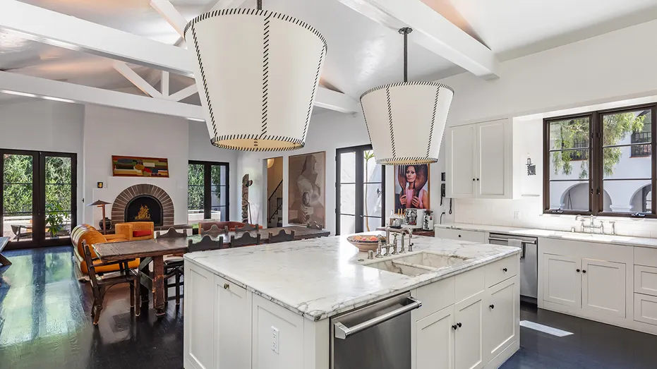 The kitchen features a large center island as well as a dining and lounge area with a fireplace.