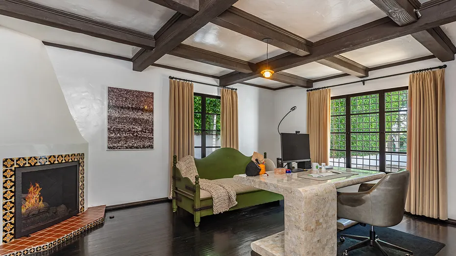 The office features dark hardwood floors and a fireplace.