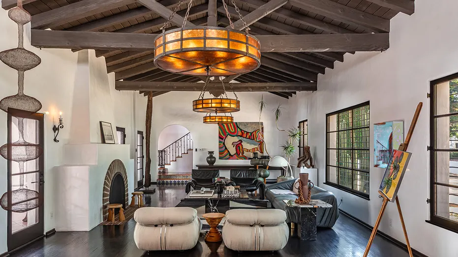 The living room features exposed beamed ceilings and a fireplace.