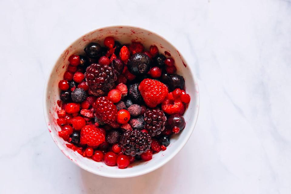 frozen berries in a bowl. flat lay. blueberries, raspberries, blackberries and cranberries.