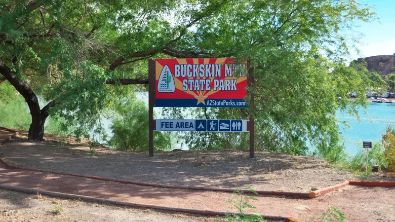 Buckskin Mountain State Park sign, surrounded by trees