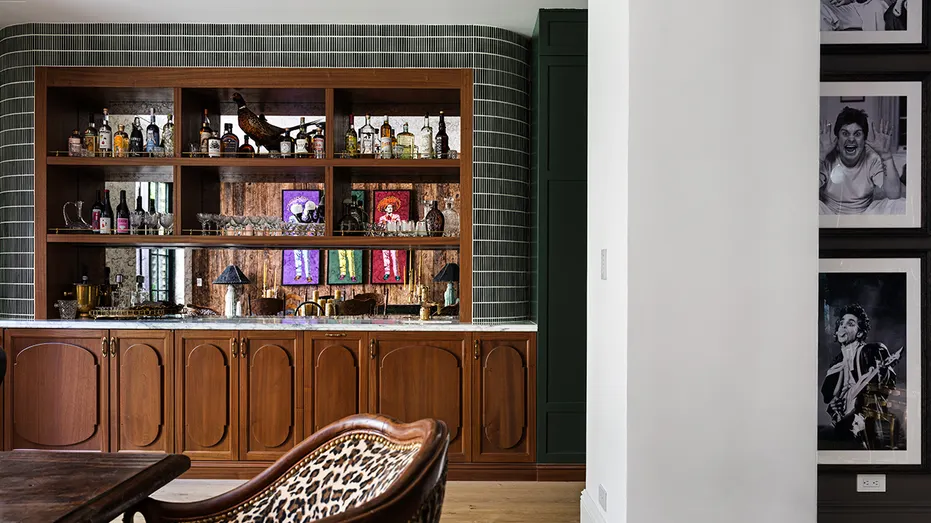 The sitting room leads to the formal dining room, which also includes a bar.