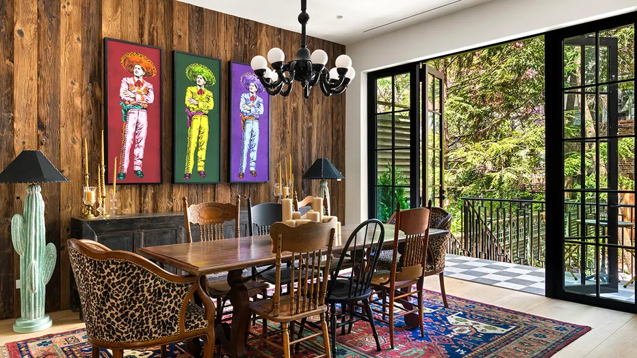 The dining room boasts colorful pictures on the wall and access to the outside.