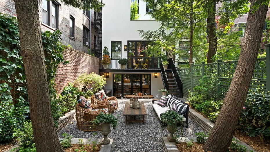 The backyard features greenery and seating and dining areas.