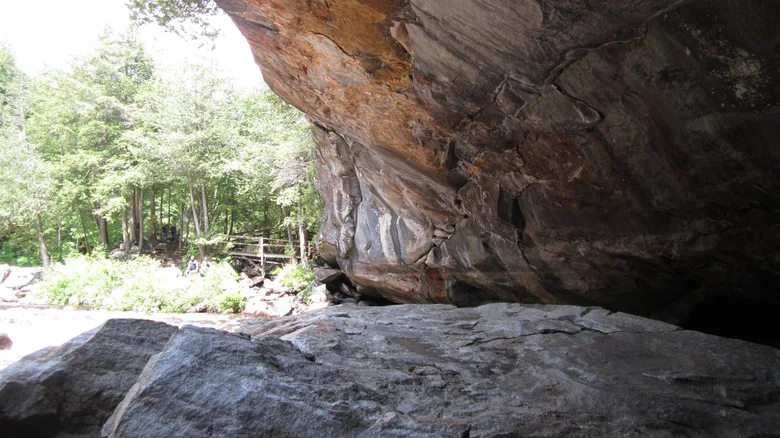 View from inside a cave in Pottersville, New York in the Adirondack Mountains during the day with a small wooden walkway in the background