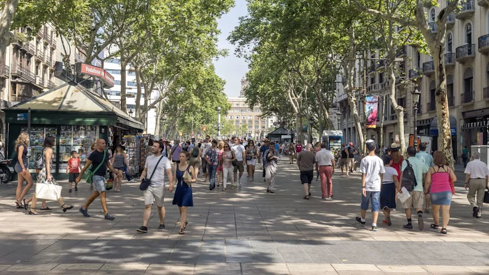 BARCELONA, SPAIN - JULY 6, 2015: Hundreds of people promenading in the busiest street of Barcelona, the Ramblas.