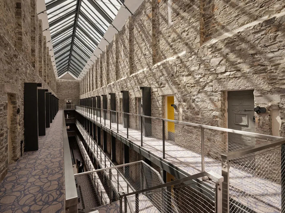 View of corridor with doorways of the rooms in the Bodmin Jail Hotel with a skylight above. - Courtesy of Bodmin Jail Hotel